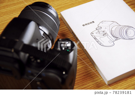 木目の机に置いたデジタル一眼レフカメラと付属の説明書 木目の机に置いたデジタル一眼レフカメラと付属の説明書 78239181