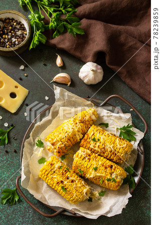 Summer vegan dinner or snacks. Grilled corn with garlic butter, served with cheese on a dark stone table top. Summer vegan dinner or snacks. Grilled corn with garlic butter, served with cheese on a dark stone table top. 78239859