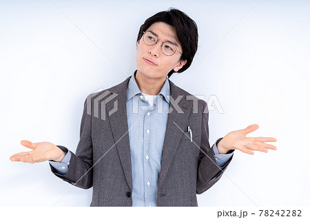 お手上げポーズをする眼鏡をかけたスーツの男性 78242282