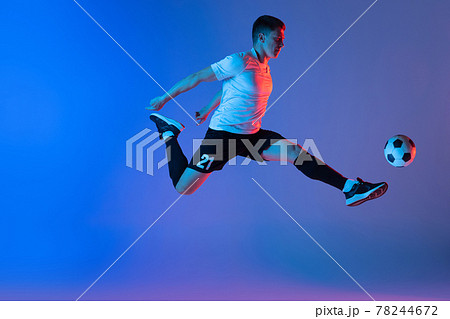 Young Caucasian man, male soccer football player jumping isolated on gradient blue pink background in neon light Young Caucasian man, male soccer football player jumping isolated on gradient blue pink background in neon light 78244672