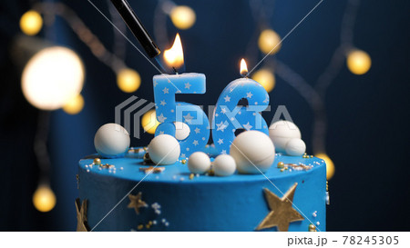 Birthday cake number 56 stars sky and moon concept, blue candle is fire by lighter. Copy space on right side of screen. Close-up Birthday cake number 56 stars sky and moon concept, blue candle is fire by lighter. Copy space on right side of screen. Close-up 78245305
