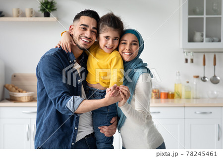 Happy Muslim Family Of Three With Little Daughter Posing In Kitchen Happy Muslim Family Of Three With Little Daughter Posing In Kitchen 78245461