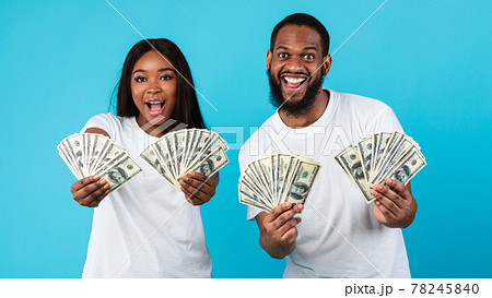 Excited African American couple holding a lot of dollar money Excited African American couple holding a lot of dollar money 78245840