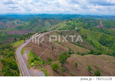 Aerial view of cars driving on curved, zigzag curve road or street on mountain hill with green natural forest trees in rural area of Nan, Thailand. Transportation. Aerial view of cars driving on curved, zigzag curve road or street on mountain hill with green natural forest trees in rural area of Nan, Thailand. Transportation. 78251226