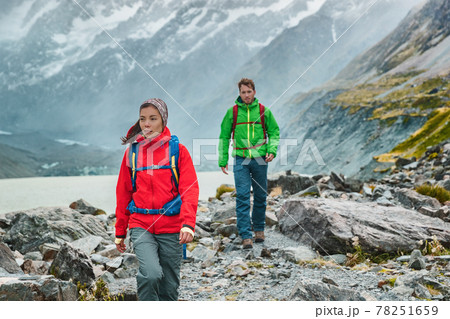People hiking travel lifestyle. People on hike wearing backpacks in nature landscape with glacier in small icebergs in Tasman Lake on New Zealand in Aoraki Mount Cook national park. People hiking travel lifestyle. People on hike wearing backpacks in nature landscape with glacier in small icebergs in Tasman Lake on New Zealand in Aoraki Mount Cook national park. 78251659