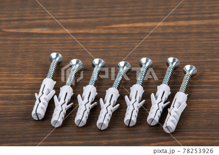Screws with dowels on a wooden texture table Screws with dowels on a wooden texture table 78253926