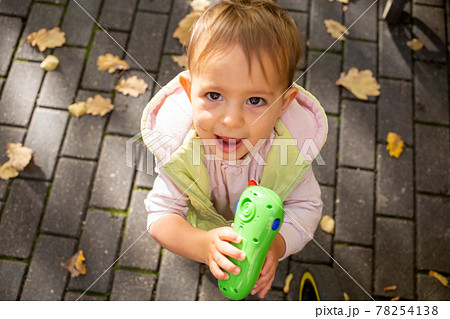 portrait of happy cute toddler playing toy phone in autumn park portrait of happy cute toddler playing toy phone in autumn park 78254138