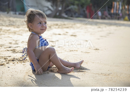 adorable toddler girl playing on sandy beach of tropical island adorable toddler girl playing on sandy beach of tropical island 78254239