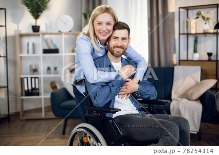 Pretty wife embracing her disabled husband 78254314