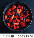 Fresh berries on dark plate on table 78254578