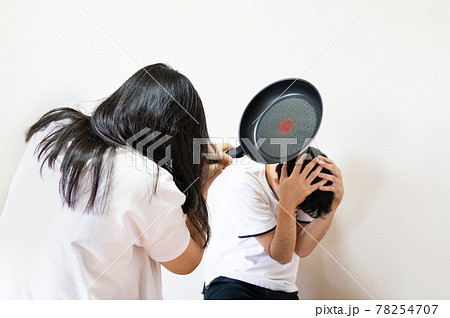 フライパンで殴りつける夫婦の写真。家庭内暴力のイメージ。 78254707