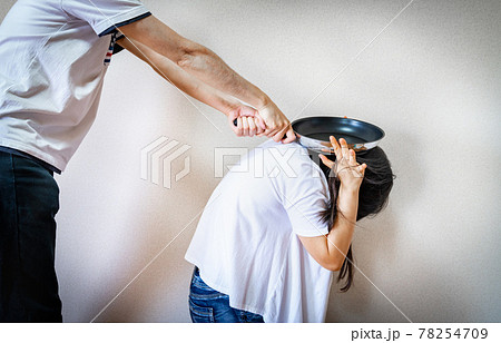 フライパンで殴りつける夫婦の写真。家庭内暴力のイメージ。 フライパンで殴りつける夫婦の写真。家庭内暴力のイメージ。 78254709