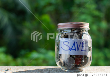 Blurred background, Coins and text SAVE in a glass jar placed on a wooden table. Concept of saving money for investment and emergency situations Or during the coronavirus (COVID-19) outbreak. Close up Blurred background, Coins and text SAVE in a glass jar placed on a wooden table. Concept of saving money for investment and emergency situations Or during the coronavirus (COVID-19) outbreak. Close up 78256561