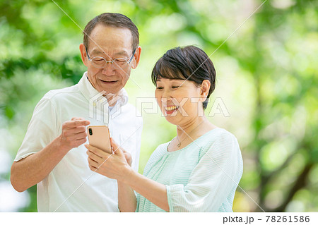 スマホを持つシニア夫婦 新緑 スマホを持つシニア夫婦 新緑 78261586