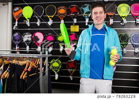 male holding new rocket and balls for padel 78263229