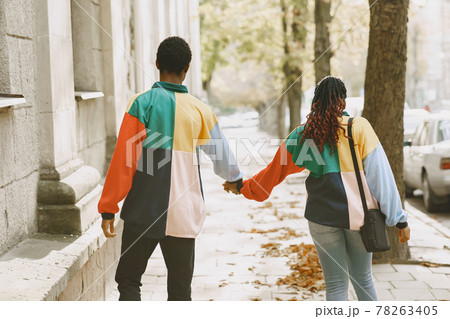 Ethnic couple walking in city street 78263405