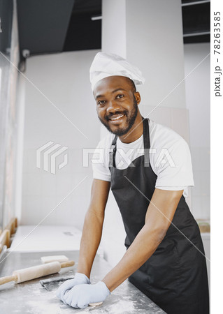 Cheerful chef preparing dough for pizza at bakery 78263585