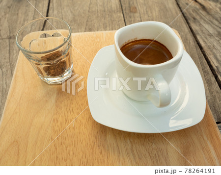 Espresso coffee in a white cup with a glass of brown sugar, Hot drink with brown table in background	 78264191