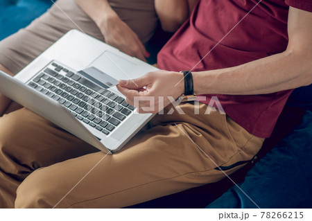 A man and a woman sitting on the sofa with a laptop 78266215