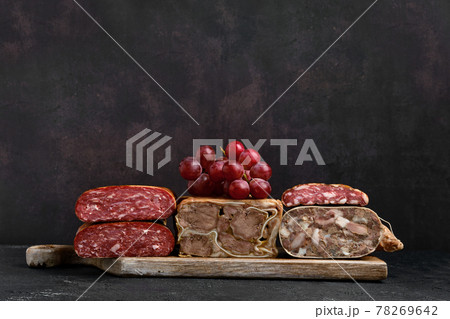 Wooden board with boiled pork meat roll, beef tongue roll and homemade sausage Wooden board with boiled pork meat roll, beef tongue roll and homemade sausage 78269642