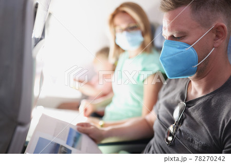 Young family is flying in airplane wearing protective medical mask 78270242