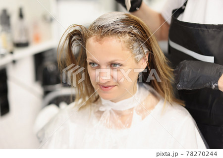 Hairdresser dying hair of client woman in barbershop 78270244
