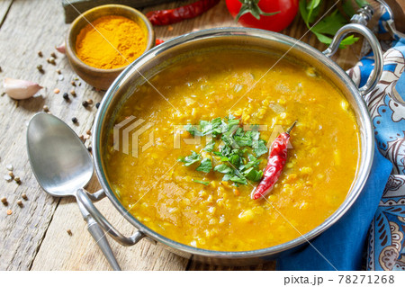 Indian food, a real Indian dish. Traditional Indian spicy lentil puree soup with herbs on a rustic table. 78271268