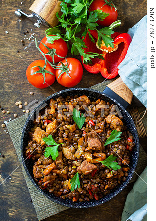 Indian cuisine dish. Traditional indian spicy green lentils with meat, spices, herbs in a cast-iron frying pan on a wooden table. Top view flat lay background. Copy space. 78273209