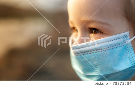 Happy little girl with protective mask looking away 78273584