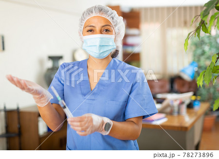 Positive woman healthcare worker holding syringe for injection Positive woman healthcare worker holding syringe for injection 78273896