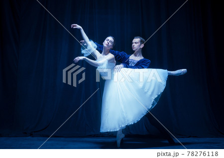 Young woman in wedding dress and man, two ballet dancers in art performance dancing isolated over dark background. 78276118