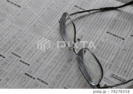 新聞の株式欄とメガネ 78276358