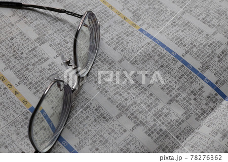 新聞の番組欄とメガネ 78276362