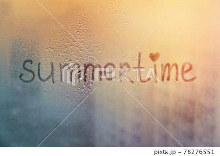 Foggy glass on window with written finger word summertime on muddy blue glass wet orange window in city on sunset Foggy glass on window with written finger word summertime on muddy blue glass wet orange window in city on sunset 78276551