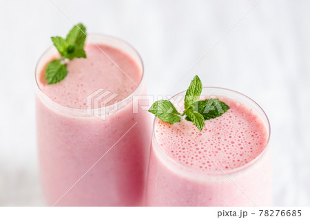 Two glasses of strawberry milkshake. Two glasses of strawberry milkshake. 78276685
