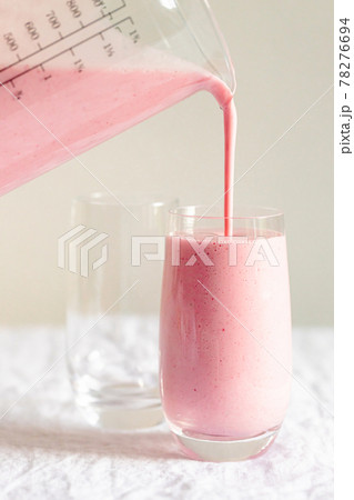 Strawberry milkshake pouring in glass. Strawberry milkshake pouring in glass. 78276694