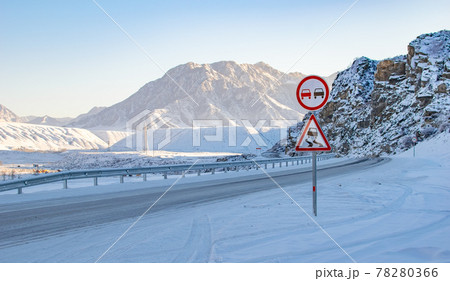 road sign on a slippery road against the background of a winter mountain landscape road sign on a slippery road against the background of a winter mountain landscape 78280366