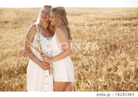 Mother with beautiful daughter in a autumn field Mother with beautiful daughter in a autumn field 78281965