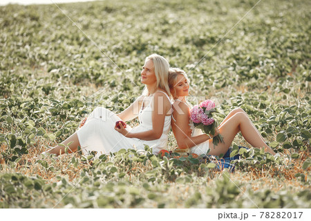 Mother with beautiful daughter in a autumn field Mother with beautiful daughter in a autumn field 78282017