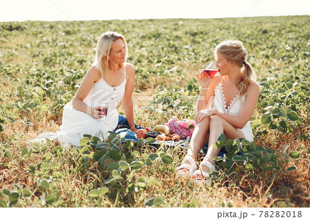 Mother with beautiful daughter in a autumn field Mother with beautiful daughter in a autumn field 78282018