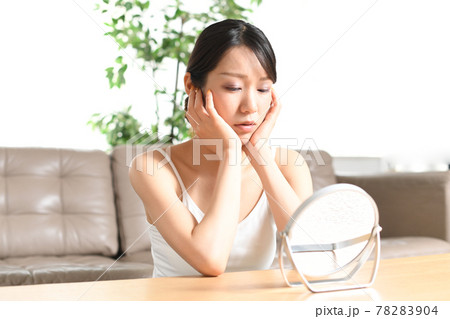 鏡を見ながら肌トラブルに悩む女性 78283904