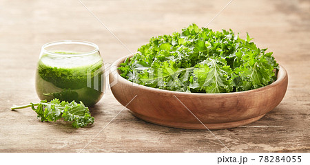 Healthy green kale smoothie with kale salad on wooden board Healthy green kale smoothie with kale salad on wooden board 78284055