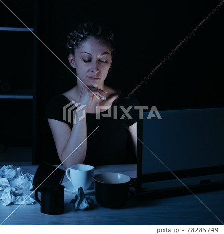Night work. Woman drinking coffee working late Night work. Woman drinking coffee working late 78285749