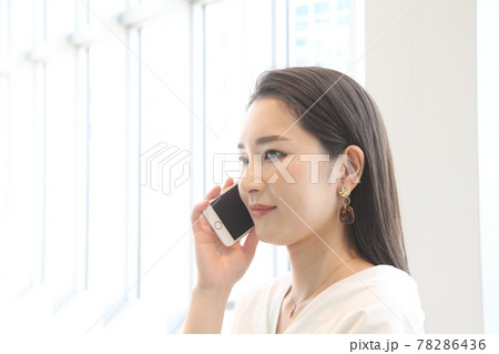 携帯をかける若い綺麗な女性 78286436
