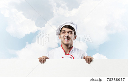 Young male chef with blank signboard 78288057