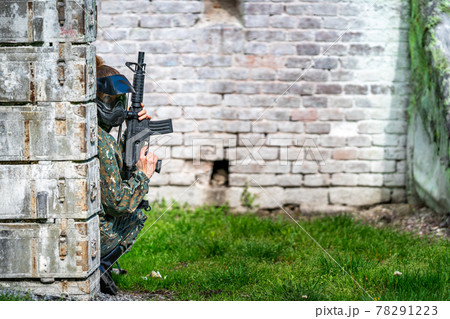 woman in uniform with a gun in military paintball training 78291223