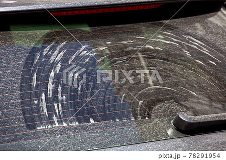 rear window of a dirty car covered with a layer of dust and dirt with stains from the windshield wiper swipe close-up. rear window of a dirty car covered with a layer of dust and dirt with stains from the windshield wiper swipe close-up. 78291954