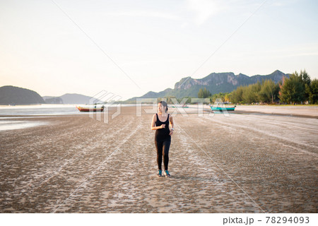 Happy asian woman running on the beach in the morning 78294093