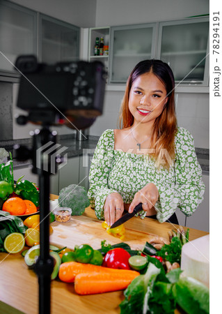 Asian woman blogger or content creator cooking and recording video camera. showing healthy food Asian woman blogger or content creator cooking and recording video camera. showing healthy food 78294191