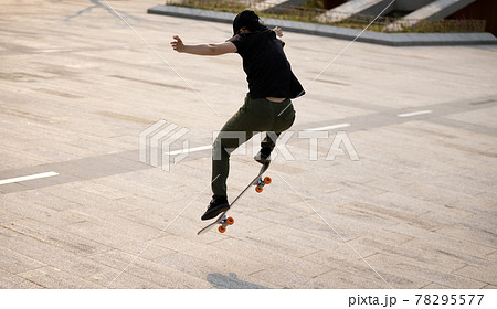 Skateboarder skateboarding outdoors in the morning 78295577